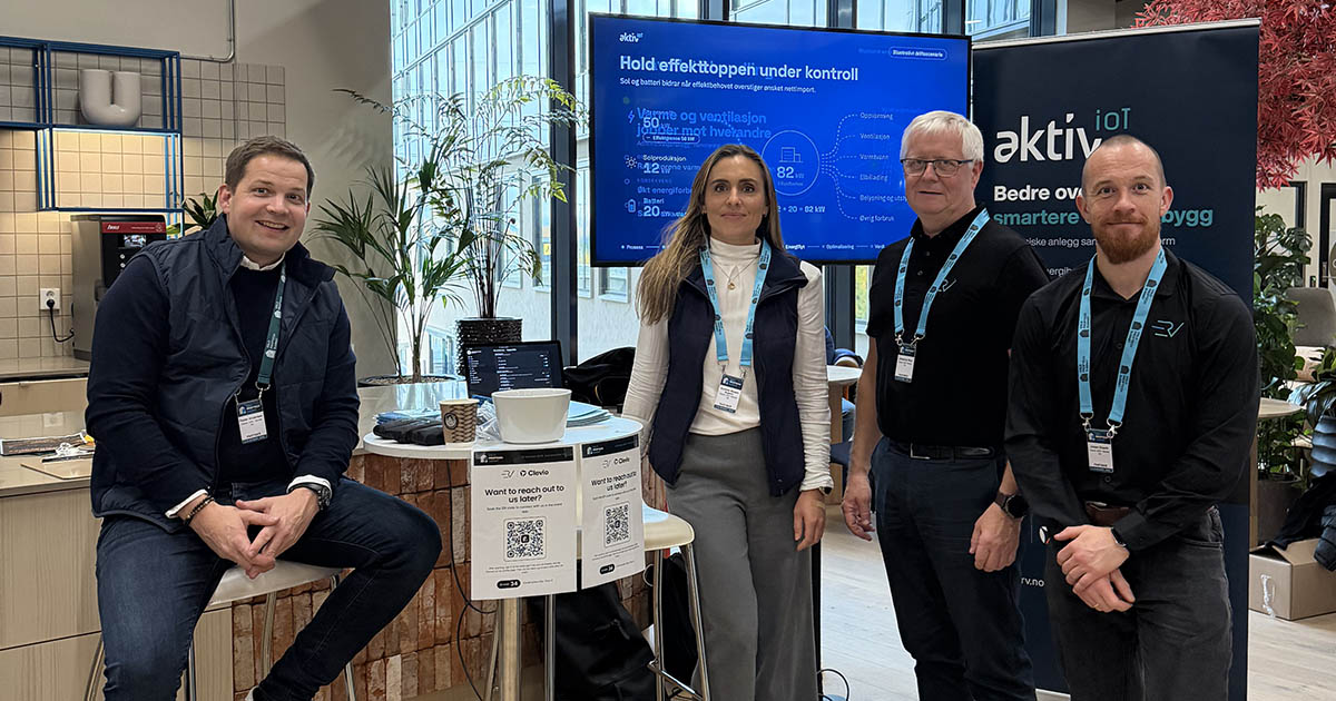 Fire personer på Clevio og ERVs felles stand på Oslo Proptech Summit 2026, foran en skjerm og en roll-up om AktivIoT.
